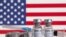 Vials labelled "COVID-19 Coronavirus Vaccine" and sryinge are seen in front of displayed USA flag in this illustration