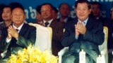 Cambodian Prime Minister Hun Sen, front right, applauses together with the National Assembly President Heng Samrin, front left, during an event by the ruling Cambodian People's Party marking the 36th anniversary of the 1979 downfall of the Khmer Rouge reg