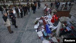 People visit the site of the Obelisk of Theodosius where Tuesday's suicide bomb attack took place at Sultanahmet Square in Istanbul, Turkey, Jan. 14, 2016.