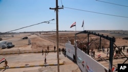 Iraqi and Syrian border guards prepare to open the crossing between the Iraqi town of Al Qaim and Syria's Albukamel in Qaim, Sept. 30, 2019.