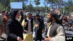 An Afghan woman protester speaks with a member of the Taliban during a protest in Herat on Sept. 2, 2021.