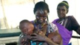 FILE - A mother breastfeeds her severely malnourished eight-month-old twins in a health clinic in Pibor, South Sudan, Dec. 16 2020. 