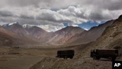 FILE - Indian army trucks drive near Pangong Tso lake near the India-China border, Sept. 14, 2017, in India's Ladakh region, where the two countries continue to be locked in a standoff.