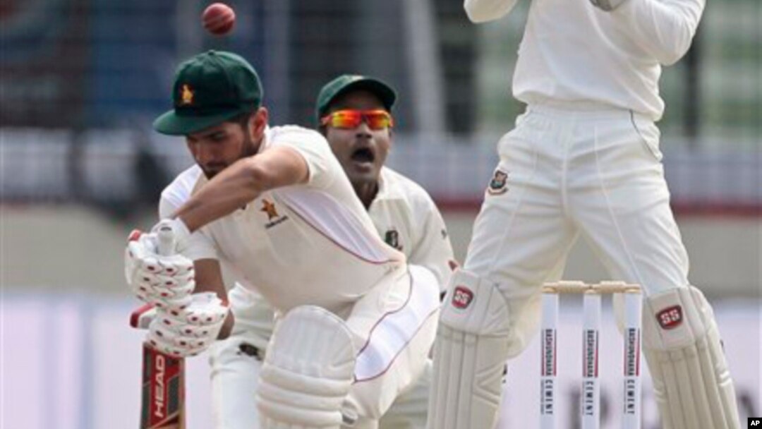 Zimbabwean cricketer Sikandar Raza, left, bats, against Bangladesh.