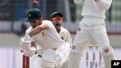 Zimbabwean cricketer Sikandar Raza, left, bats, against Bangladesh.