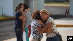 Los familiares de una de las víctimas que murieron durante un ataque a un bar lloran frente a la oficina del fiscal del estado de Veracruz en Coatzacoalcos, México, el miércoles 28 de agosto de 2019. (AP Foto / Félix Márquez)