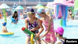 FILE - Visitors cool off at Munsu Water Park east of Pyongyang, North Korea — a project in which wealthy individuals known as Donju are said to have played a key role.