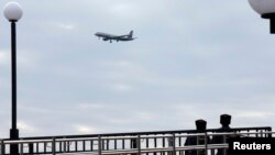 Russian Cossacks patrol the Adler district of Sochi, with a plane flying by in the background, Jan. 22, 2014.