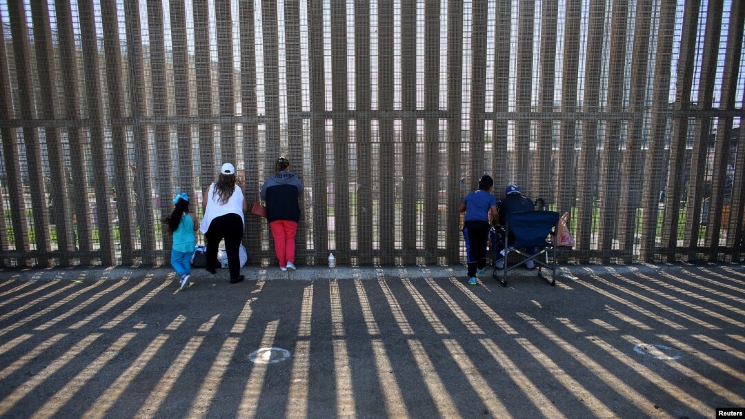 FILE - People hold conversations through the U.S. Mexico border wall at Border Field State Park in San Diego, California, Nov. 18, 2017. 