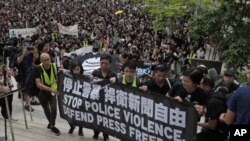 Jornalistas em Hong Kong exibem cartazes a pedir o fim da violência da polícia e a defender a liberdade de imprensa. 14 de Julho 2019