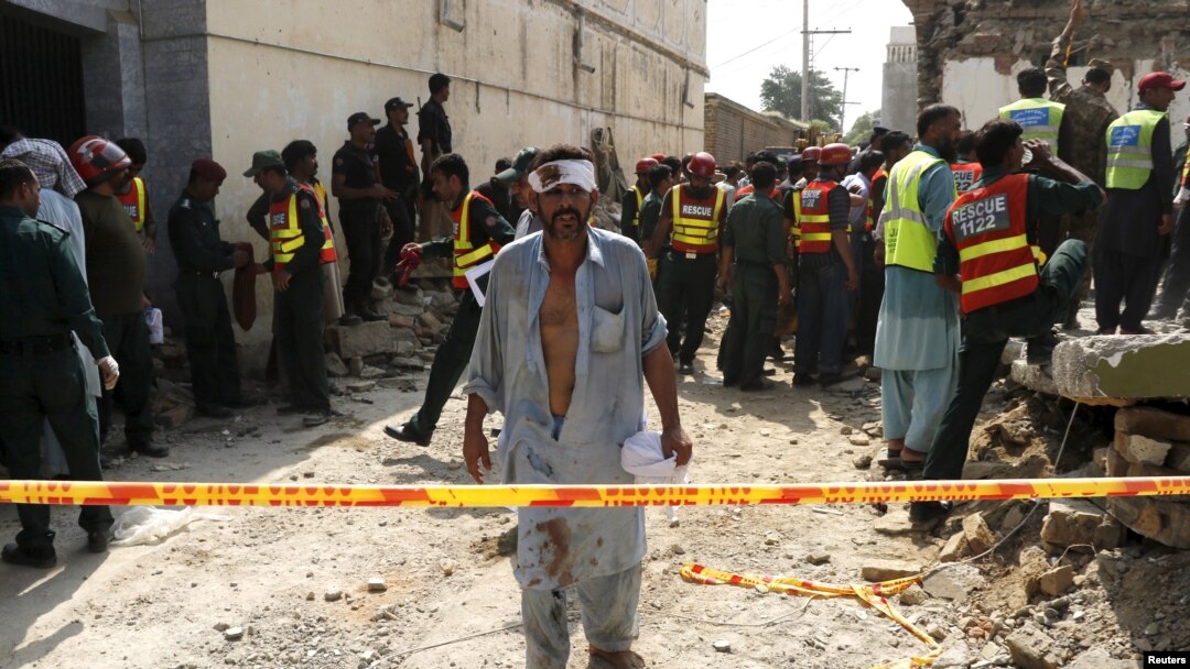 Seorang pria yang terluka menjauh saat saat para petugas membantu pencarian para korban serangan bom di Shuja Khanzada, provinsi Punjab, Atok, Pakistan, 16 Agustus 2015 (Foto: dok). 