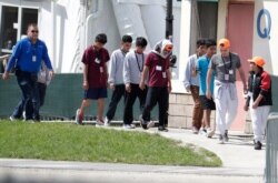 In this July 15, 2019 file photo, migrant children walk on the grounds of the Homestead Temporary Shelter for Unaccompanied Children, in Homestead, Fla.