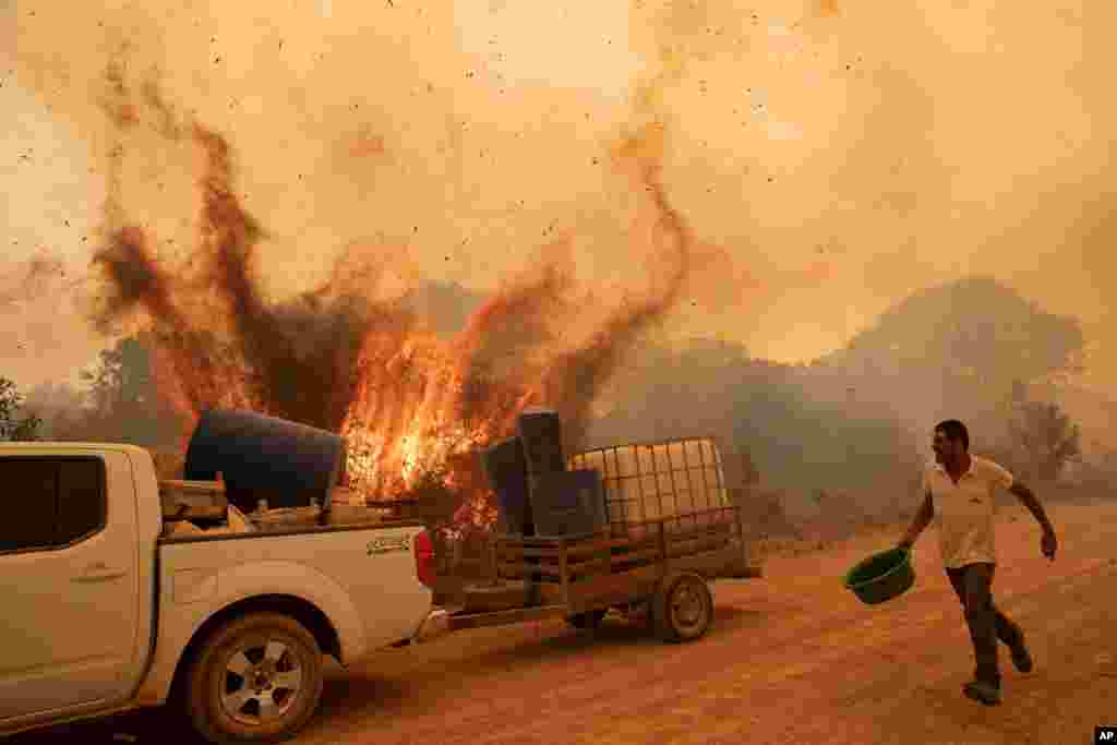 Volunteer Divino Humberto tries to douse the fire along a dirt road off the Trans-Pantanal highway, in the Pantanal wetlands near Pocone, Mato Grosso state, Brazil.
