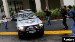 FILE- A vehicle belonging to the Brazilian Federal Revenue Authority leaves the headquarters of Brazilian conglomerate Camargo Correa during "Operation Carwash" in Sao Paulo, Nov. 14, 2014. Fifteen search warrants in the "Operation Carwash” probe were issued Wednesday. 