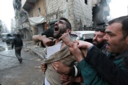 FILE - A father reacts after the death of two of his children, who activists said were killed by shelling by forces loyal to Syria's President Bashar al-Assad, in Aleppo's al-Ansari area, Jan. 3, 2013.
