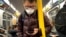 In this March 19, 2020 photo, a commuter wears a face mask while riding the subway in New York. 