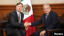 ARCHIVO - El entonces presidente mexicano Andrés Manuel López Obrador estrecha la mano del embajador de EEUU en esa nación, Christopher Landau, durante una reunión en México el 26 de agosto de 2019.