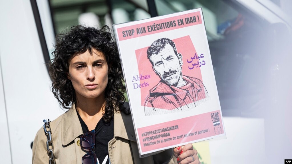 FILE - Actor Barbara Pravi holds a placard that reads "Stop executions in Iran" during a march in Paris on the second anniversary of a protest movement sparked by the death in morality police custody of Mahsa Amini, Sept. 15, 2024.