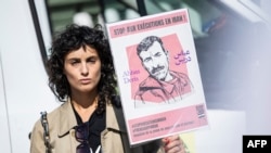 FILE - Actor Barbara Pravi holds a placard that reads "Stop executions in Iran" during a march in Paris on the second anniversary of a protest movement sparked by the death in morality police custody of Mahsa Amini, Sept. 15, 2024.