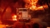 FILE - Flames from the Glass Fire burn a truck in a Calistoga, Calif., vineyard, Oct. 1, 2020. 