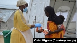 Un personnel soignant donne des médicaments contre le choléra à une mère et son enfant, au Nigeria, 27 septembre 2017. (Ocha Nigeria)