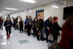 FILE - New voters, including many University of New Hampshire students, stand in line to fill out voter registration forms in Durham, New Hampshire, Nov. 6, 2018.
