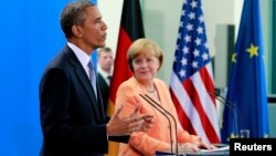 El presidente Barack Obama habla mientras la canciller alemana Angela Merkel escucha, durante la conferencia de prensa que siguió a la reunión entre ambos líderes en Berlín.
