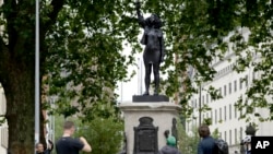 Patung demonstran "Black Lives Matter" dengan tangan mengepal ke atas di Bristol, Inggris, 15 Juli 2020. (AP Photo/Matt Dunham)