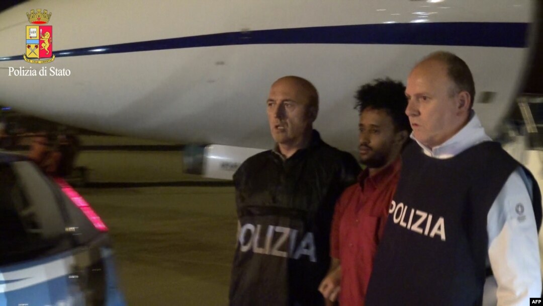 Foto yang dirilis oleh kepolisian Italia ini menunjukkan gambar Yehdego Mered (35 tahun, berkaos merah), warga Eritera yang diduga mendalangi jaringan penyelundup migran ke Italia diekstradisi dari Sudan ke Italia (8/6). 