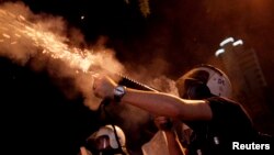 Riot police fire tear gas toward protesters during clashes in Kennedy Street in central Ankara, Turkey, June 18, 2013.