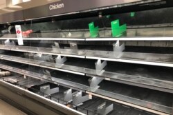 FILE - Shelves that usually hold an abundance of chicken and beef lay empty at a Target in Abington, Pennsylvania., March 18, 2020.