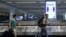 Travelers pass a sign alerting them to distance at LaGuardia Airport, during the outbreak of the coronavirus disease (COVID-19), in New York, June 29, 2020. 