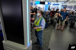 A technician removes software from an information display at Chicago O'Hare International Airport in Chicago on July 19, 2024, after software issues delayed and canceled flights globally.