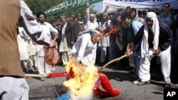 Afghan protesters burn an effigy of U.S. President Barack Obama during a demonstration in Jalalabad, Afghanistan on Sunday, April 3, 2011