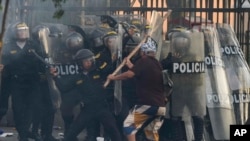 Un manifestante anti gobierno carga contra la policía con un palo durante los enfrentamientos en Lima, Perú, el jueves 19 de enero de 2023.