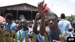 Des étudiants montrent une cartouche de gaz lacrymogène lancée par la police anti-émeute lors de leur rassemblement pour protester contre une modification des règles régissant le processus d'attribution de subventions, le 10 avril 2019 à Libreville.