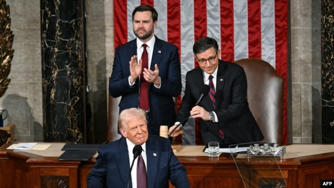 US Vice President JD Vance and Speaker of the House Mike Johnson applaud as US President Donald Trump arrives to address to a joint session of Congress in the House Chamber of the US Capitol in Washington, DC, on March 4, 2025. (Photo by Jim WATSON / AFP)