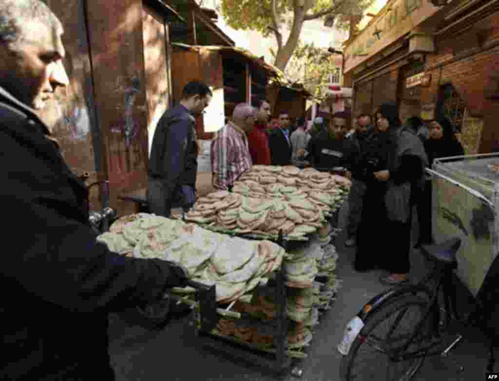 Bread vendors pull their trolley to their shop in Cairo, Egypt, Wednesday, Feb.2, 2011. Egypt's economy suffered a fresh blow after yet another credit agency lowered its ratings and its currency approached a five-year low with slim chance of a quick rebo