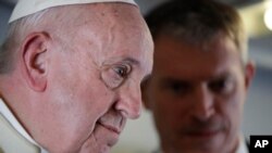 Pope Francis talks with his spokesperson Matteo Bruni, as he addresses journalists during his flight from Antamanarivo to Rome, Sept. 10, 2019, after his seven-day pastoral trip to Mozambique, Madagascar, and Mauritius. 