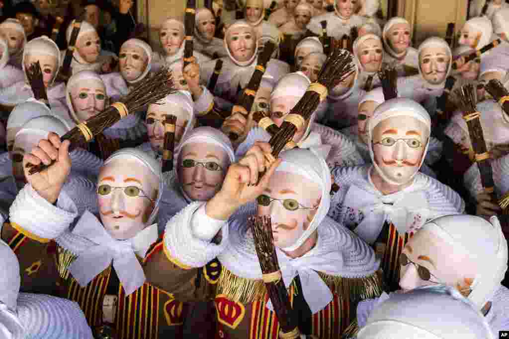 A group of people dressed as &#39;Gilles of Binche&#39;, arrive to pick up their jubilee medals at the City Hall on the Grand Place, during the Carnival of Binche, in Binche, Belgium. Up to 1,000 clown-like performers known as Gilles, appear in the city center, wearing a hat covered with ostrich feathers and a red, yellow and black medieval costume decorated with bells and with lace at the neck, wrists and ankles.