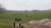 A group of migrants walk through the Turkish-Greek border in a village near Edirne, Turkey, Feb. 28, 2020. 