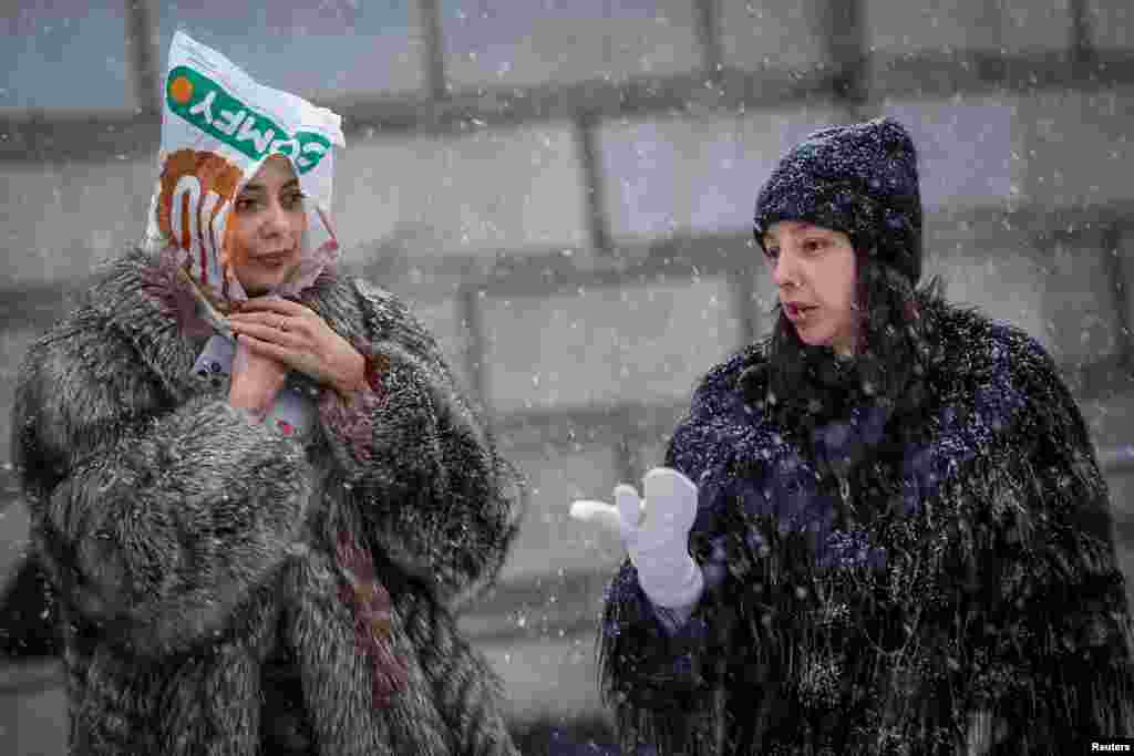 Women walk on a snow-covered street during a snowfall, in Kyiv, Ukraine.&nbsp;REUTERS/Alina Smutko