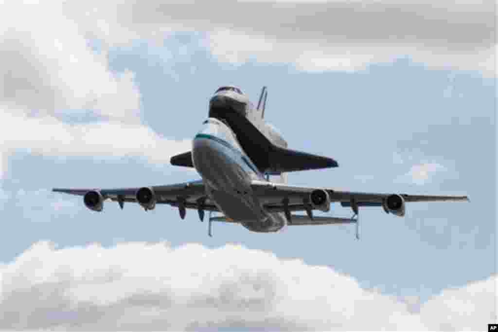 Space shuttle Enterprise, riding on the back of the NASA 747 Shuttle Carrier Aircraft performs a fly-by above JFK International Airport, Friday, April 27, 2012, in New York. Enterprise is eventually going to make its new home in New York City at the Intr