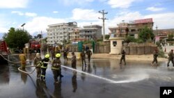 Afghan firefighters clean the site of a suicide bombing targeting a military academy in Kabul, Afghanistan, May 30, 2019. The suicide bomb killed at least six people and wounded six others Thursday, the Interior Ministry said.