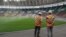 FILE - Workers from the Magil company standing near the pitch at the Olembe stadium in Yaounde, Cameroon, Aug. 8, 2021.