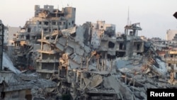 A general view shows damaged buildings on a deserted street in the besieged area of Homs Jul. 13, 2013. 