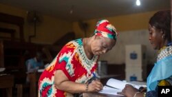 A voter prepares to cast her ballot in a polling station during the presidential elections in Kinshasa, Democratic Republic of Congo, Dec. 20, 2023.