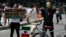 A woman holds a sign that reads in Spanish "It is not change, or crisis. It's an emergency" as she stands next to another demonstrator with a bicycle during a global protest on climate change in Mexico City, Sept. 20, 2019.