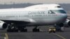 Sebuah kendaraan pengatur parkir pesawat tampak memandu pesawat Boeing B747-400 milik maskapai Cathay Pacific di bandara Frankfurt, 21 Februari 2012 (foto: Reuters)