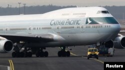 Sebuah kendaraan pengatur parkir pesawat tampak memandu pesawat Boeing B747-400 milik maskapai Cathay Pacific di bandara Frankfurt, 21 Februari 2012 (foto: Reuters)